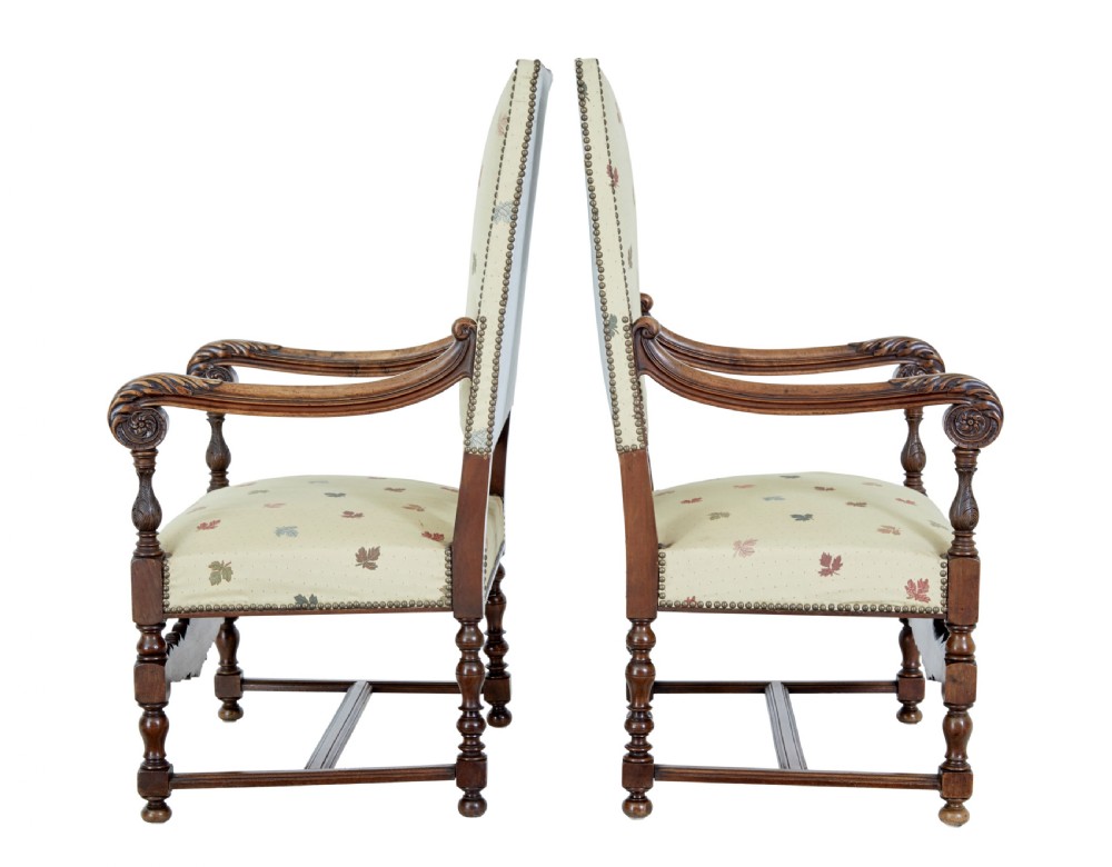 Pair of 19th-century French carved walnut armchairs with high rectangular backs, scroll arms, and cream leaf-patterned upholstery. View VI