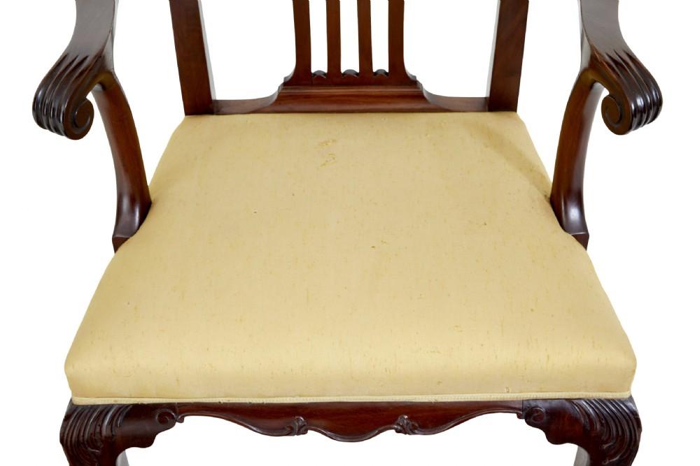 A pair of 19th-century Chippendale style mahogany armchairs featuring pierced back splats, curved armrests, yellow upholstered drop-in seats, and carved cabriole legs. View V