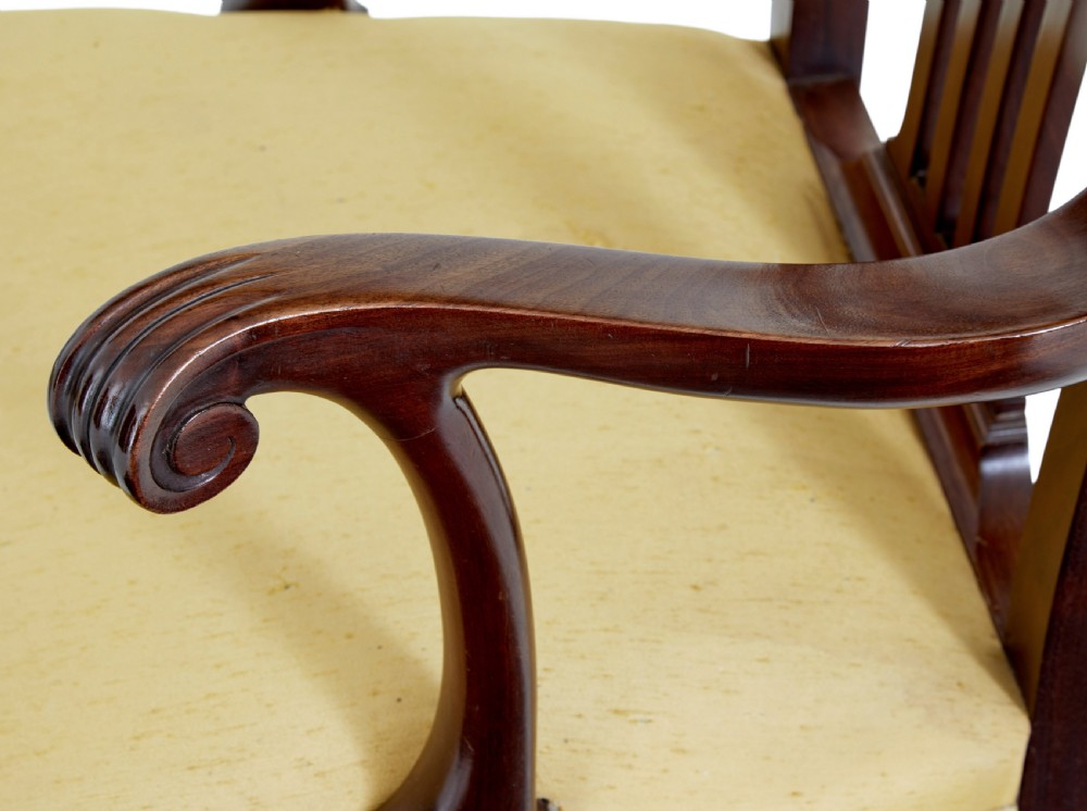 A pair of 19th-century Chippendale style mahogany armchairs featuring pierced back splats, curved armrests, yellow upholstered drop-in seats, and carved cabriole legs. View VI