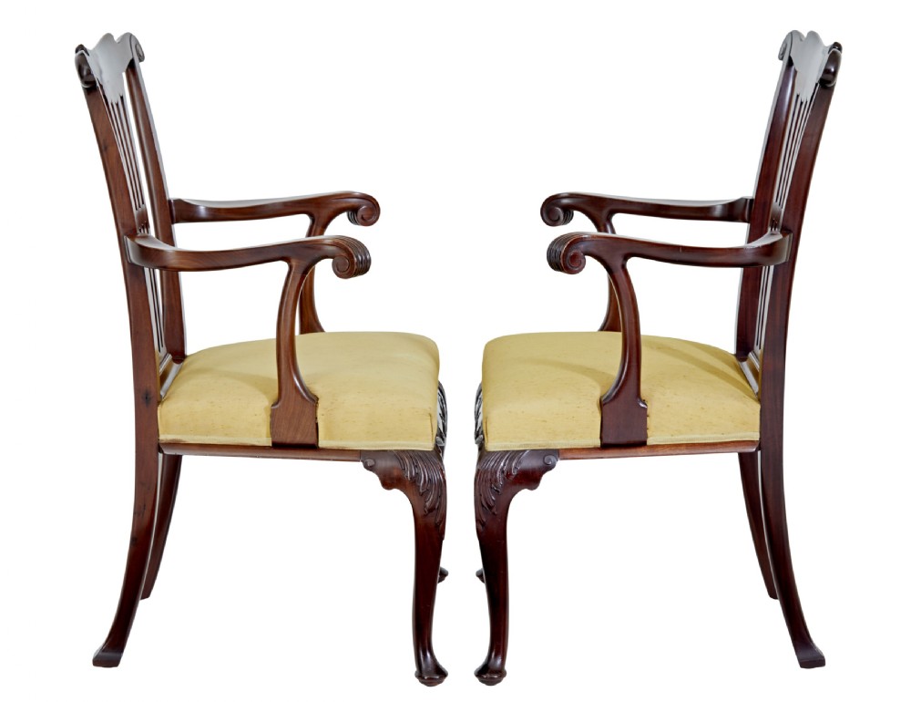 A pair of 19th-century Chippendale style mahogany armchairs featuring pierced back splats, curved armrests, yellow upholstered drop-in seats, and carved cabriole legs. View VIII