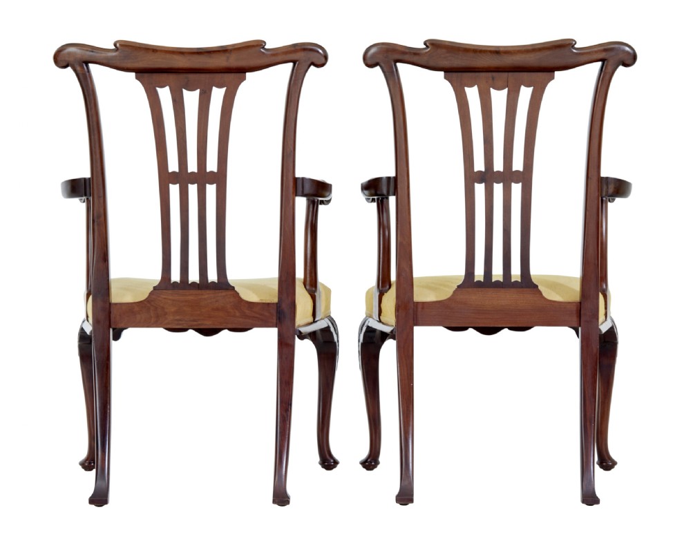 A pair of 19th-century Chippendale style mahogany armchairs featuring pierced back splats, curved armrests, yellow upholstered drop-in seats, and carved cabriole legs. View IX