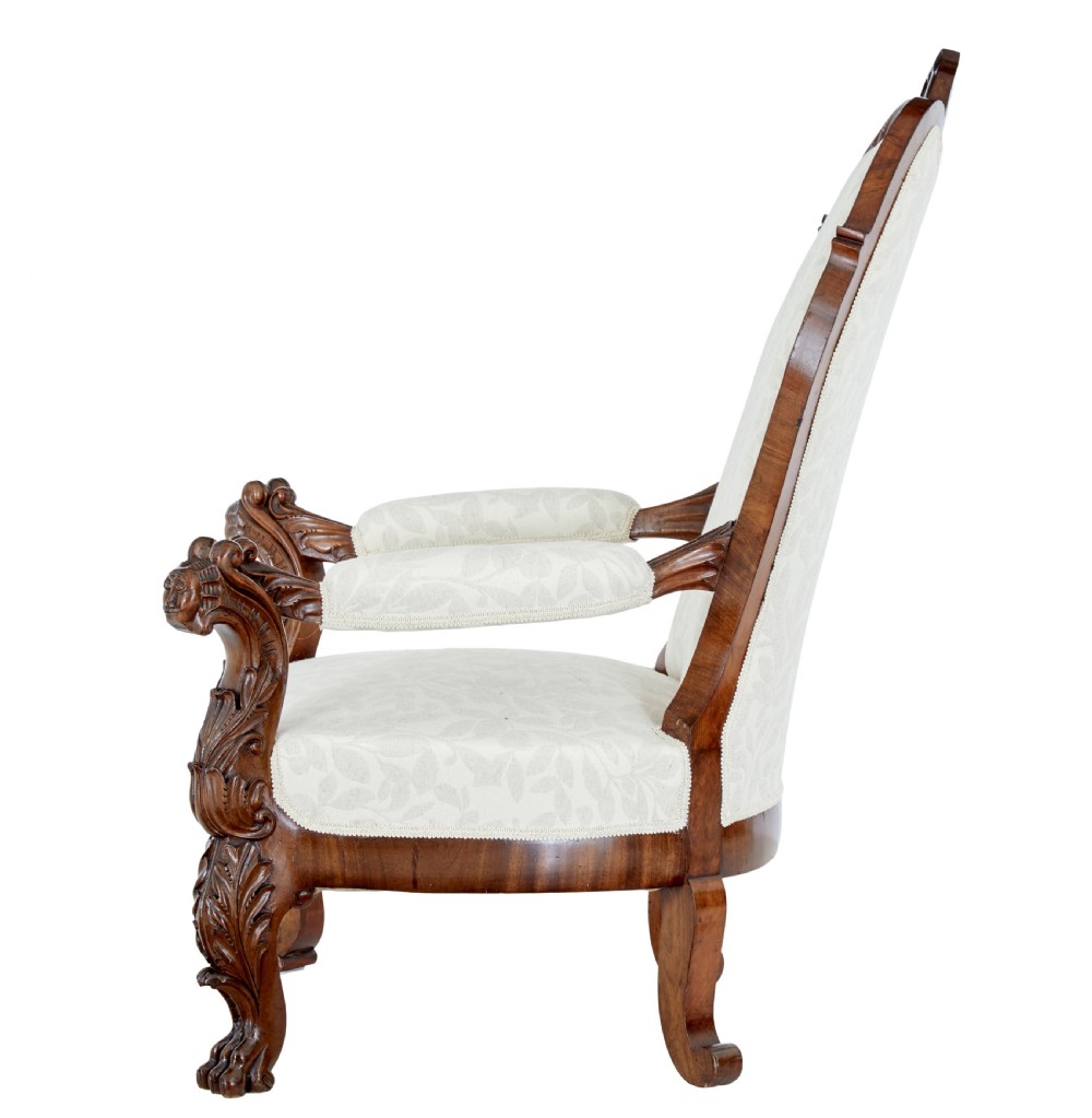 A mid-19th-century carved walnut armchair featuring figurative arm supports and cream patterned upholstery. View III