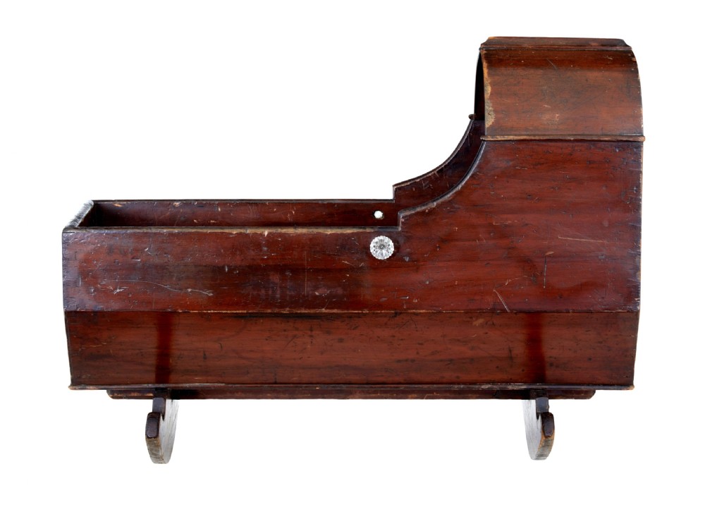 A Victorian pine rocking cradle featuring a curved canopy hood, a dark reddish-brown finish, and two solid wood rockers at the base. View IV
