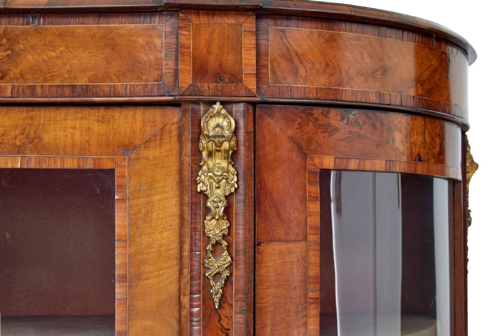 A 19th-century Victorian burr walnut glazed credenza featuring curved glass side doors and decorative gilt metal mounts. View VI