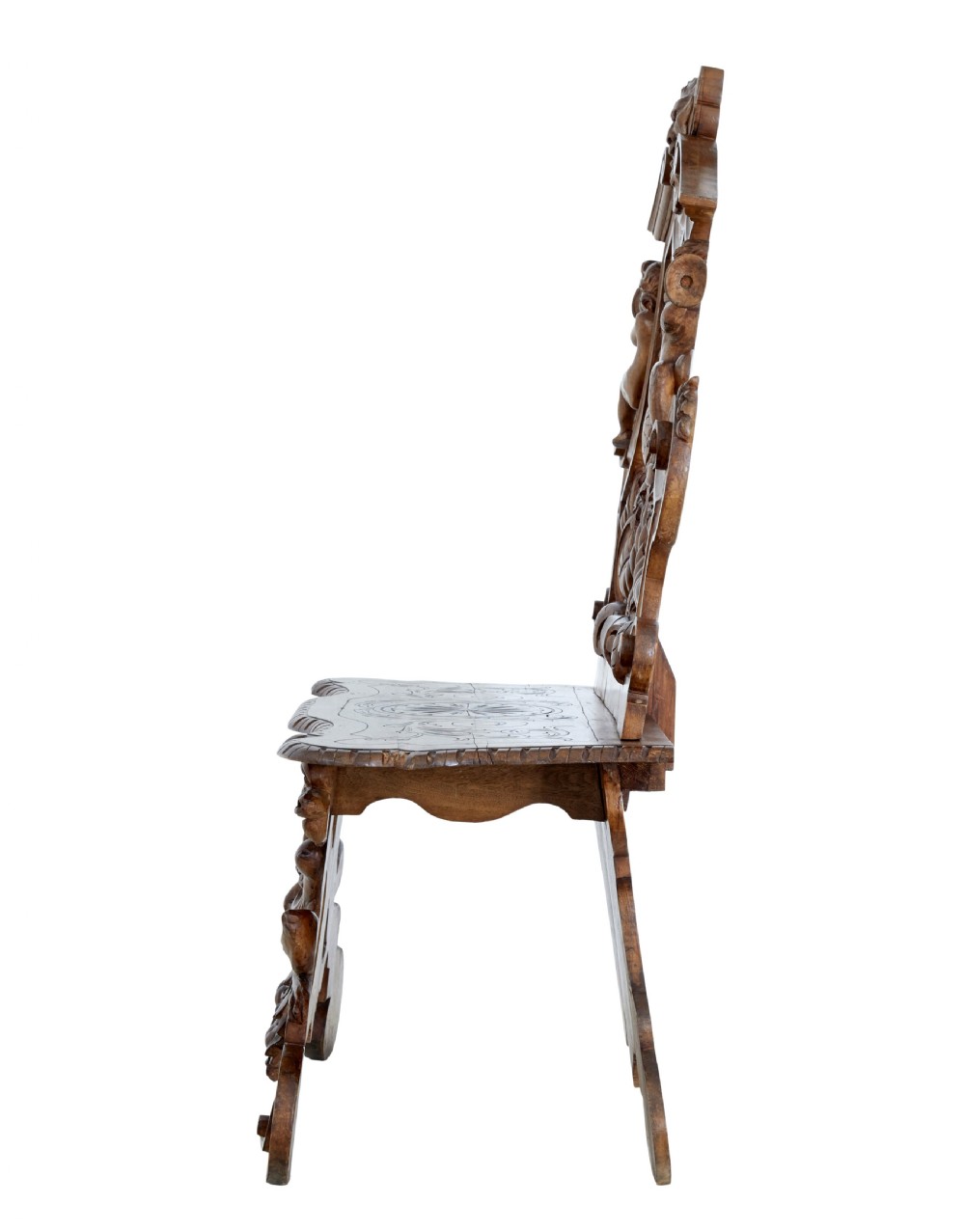 A 19th-century Flemish walnut hall chair decorated with openwork carvings of grotesque masks, cherubs blowing trumpets, and a central shield motif. View III