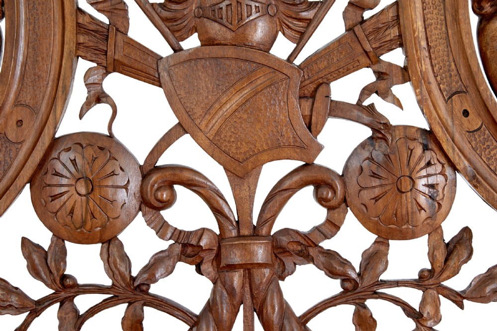 A 19th-century Flemish walnut hall chair decorated with openwork carvings of grotesque masks, cherubs blowing trumpets, and a central shield motif. View VII