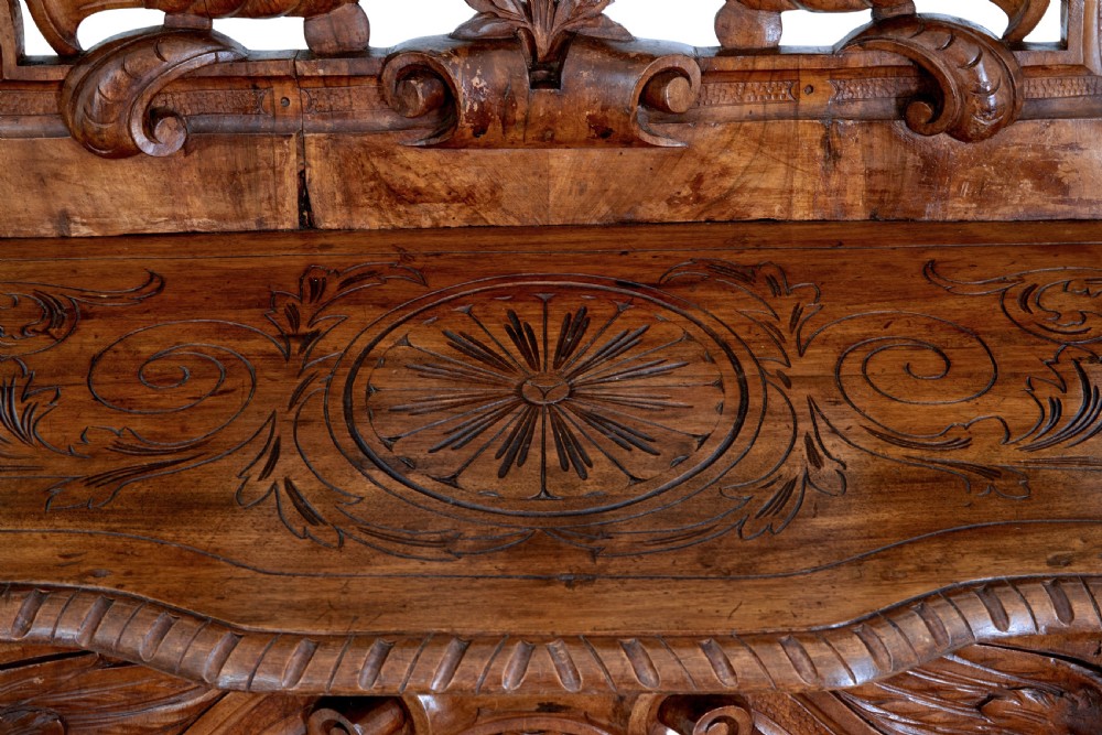 A 19th-century Flemish walnut hall chair decorated with openwork carvings of grotesque masks, cherubs blowing trumpets, and a central shield motif. View IX