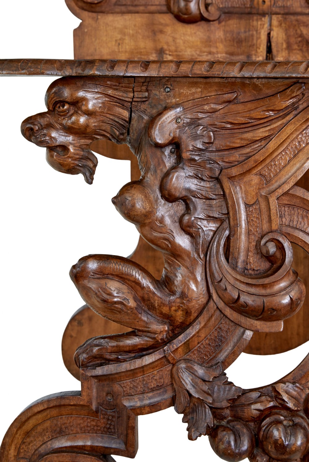 A 19th-century Flemish walnut hall chair decorated with openwork carvings of grotesque masks, cherubs blowing trumpets, and a central shield motif. View XI