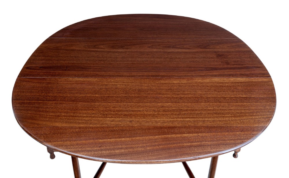 An early 20th-century mahogany gateleg dining table shown with both drop-down leaves folded against turned wooden legs. View VII
