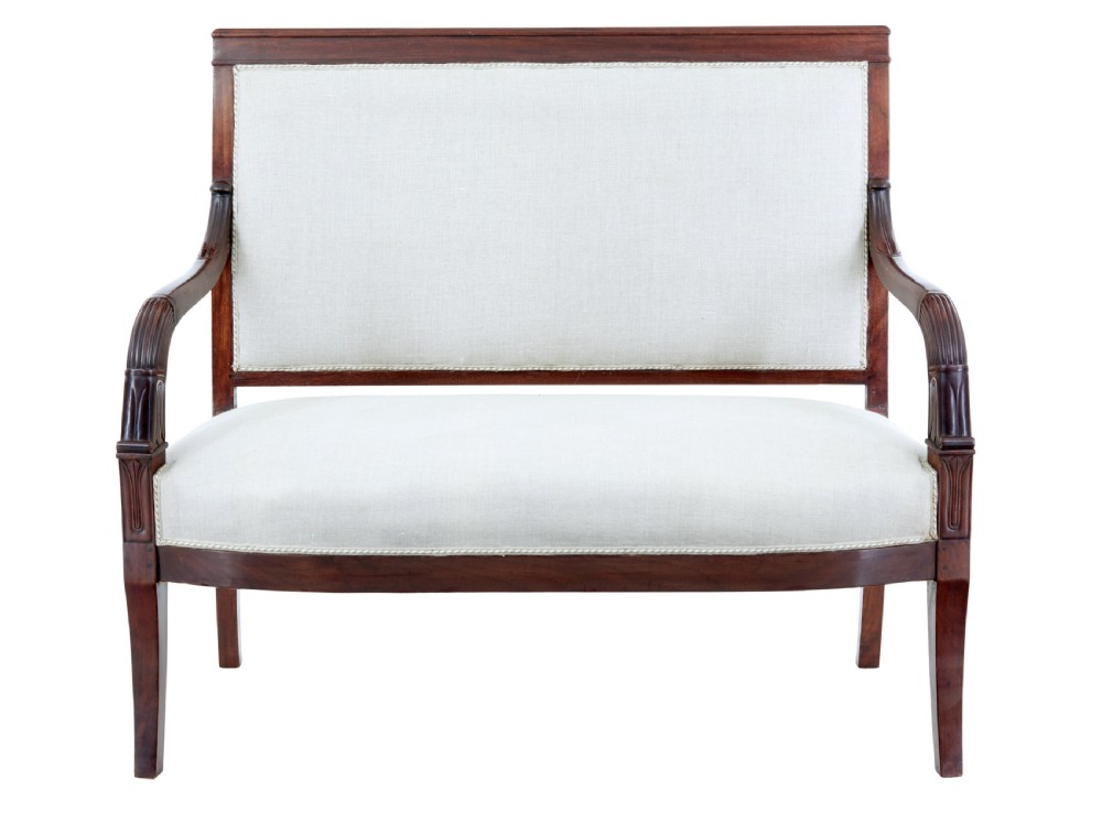 A seven-piece nineteenth-century French Empire mahogany salon suite upholstered in off-white fabric with carved reeded armrests. View II