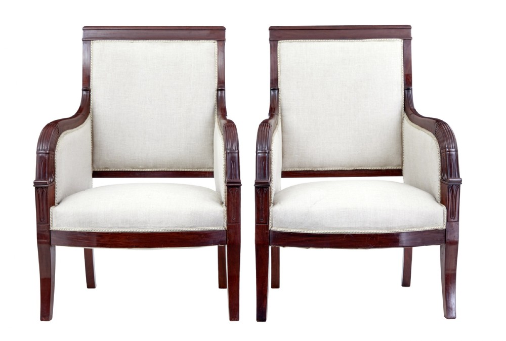 A seven-piece nineteenth-century French Empire mahogany salon suite upholstered in off-white fabric with carved reeded armrests. View V