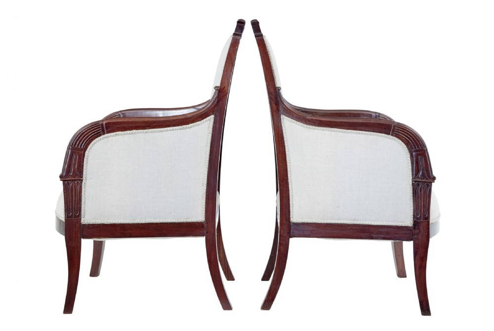 A seven-piece nineteenth-century French Empire mahogany salon suite upholstered in off-white fabric with carved reeded armrests. View VI