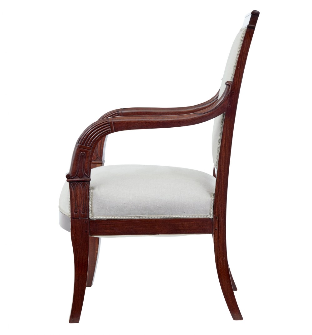 A seven-piece nineteenth-century French Empire mahogany salon suite upholstered in off-white fabric with carved reeded armrests. View IX