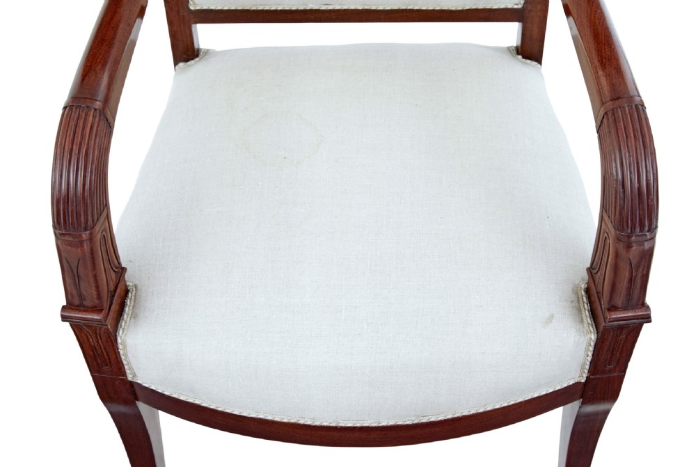 A seven-piece nineteenth-century French Empire mahogany salon suite upholstered in off-white fabric with carved reeded armrests. View X