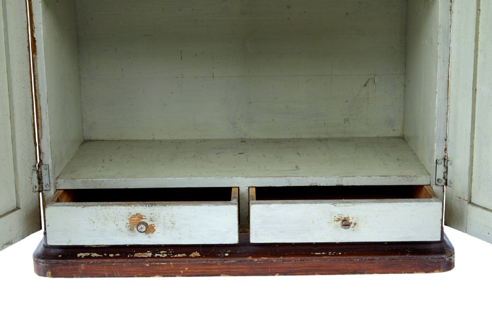 A 19th-century Scandinavian wall cabinet featuring a dark reddish-brown faux-grained paint finish, two panelled doors with brass keyholes, and a moulded top cornice. View IV