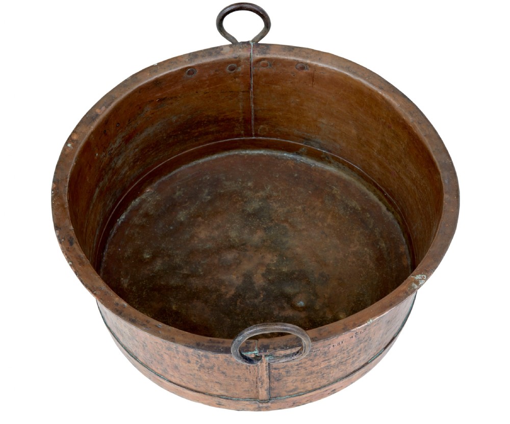 A large round 19th-century hand-hammered copper cooking vessel featuring dual vertical loop handles attached with rivets. View IV