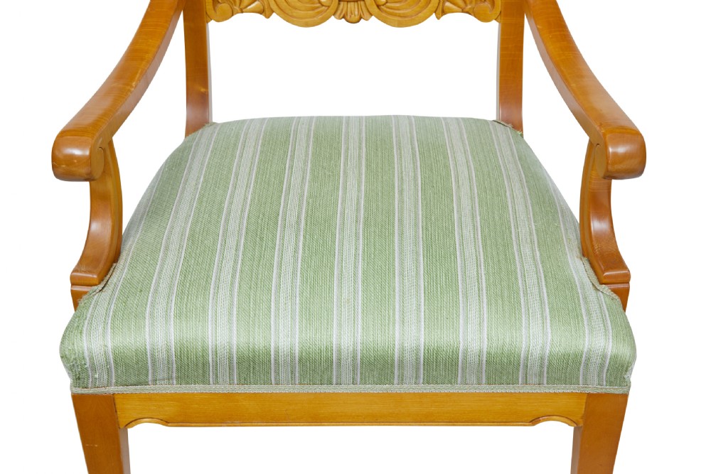 A pair of early 20th-century Swedish birch armchairs featuring carved scroll crests, central relief back rails, and green striped upholstered seats. View V