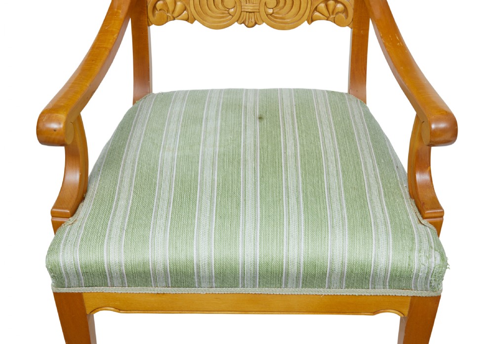 A pair of early 20th-century Swedish birch armchairs featuring carved scroll crests, central relief back rails, and green striped upholstered seats. View VI