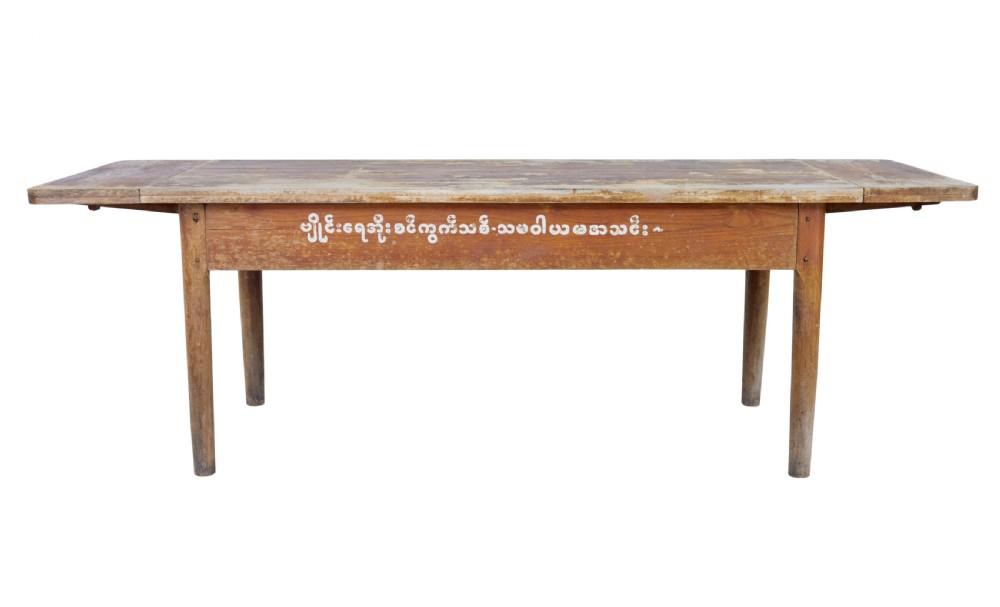A long 19th-century Burmese teak table with a weathered brown finish and white hand-painted Burmese script across the front frieze. View II