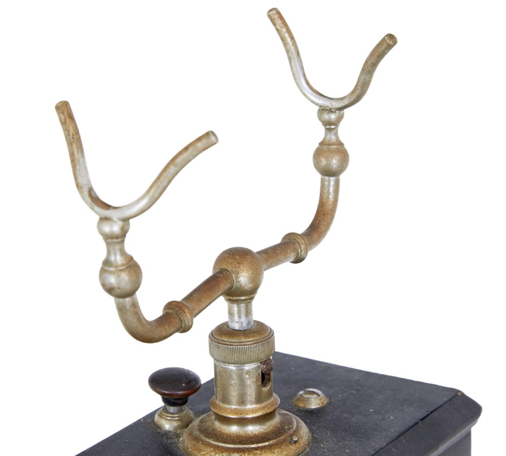 An early twentieth-century black metal Swedish Rikstelefon tabletop telephone with a brass handset cradle, fabric cord, side hand crank, and central blue crown decal. View VII