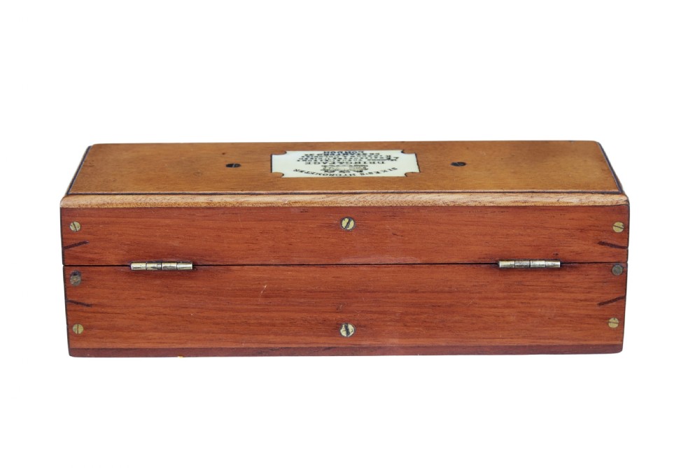 A rectangular Victorian mahogany wooden box with dual brass latches and an inlaid ivory-coloured makers plaque on the top lid. View V
