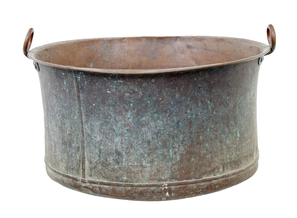A large 19th-century cylindrical copper cooking pot featuring rolled rims, riveted side handles, and surface verdigris patina.