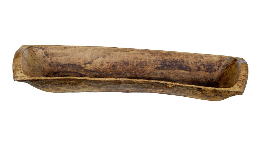 A long hand-carved wooden dugout trough featuring a weathered natural surface finish and chiselled interior.