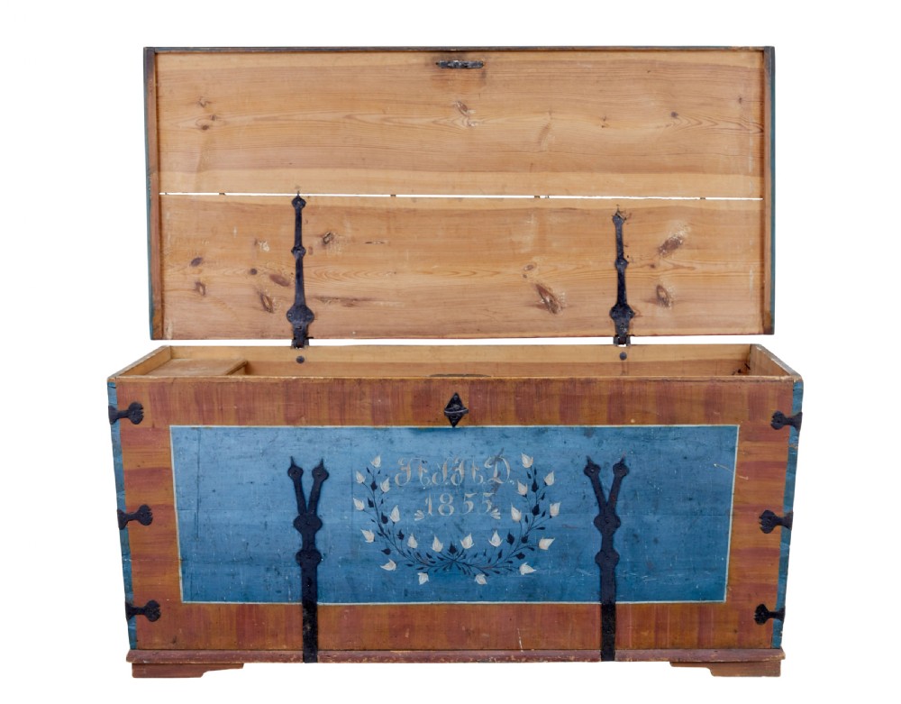 A mid-19th-century Swedish painted wooden coffer featuring blue centre panels decorated with a floral wreath and the date 1855, framed by terracotta borders and black wrought iron straps. View II