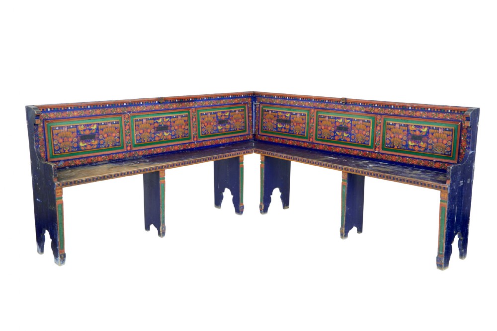 A nineteenth-century L-shaped wooden corner bench featuring hand-painted floral panels in red, green, and orange over a deep blue frame. View II