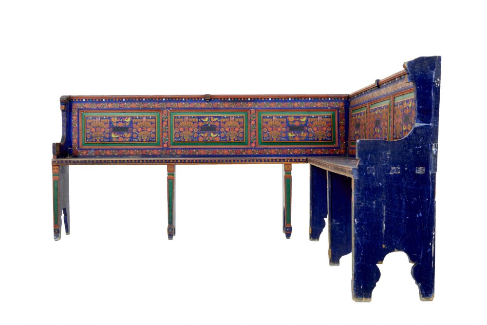 A nineteenth-century L-shaped wooden corner bench featuring hand-painted floral panels in red, green, and orange over a deep blue frame. View IV
