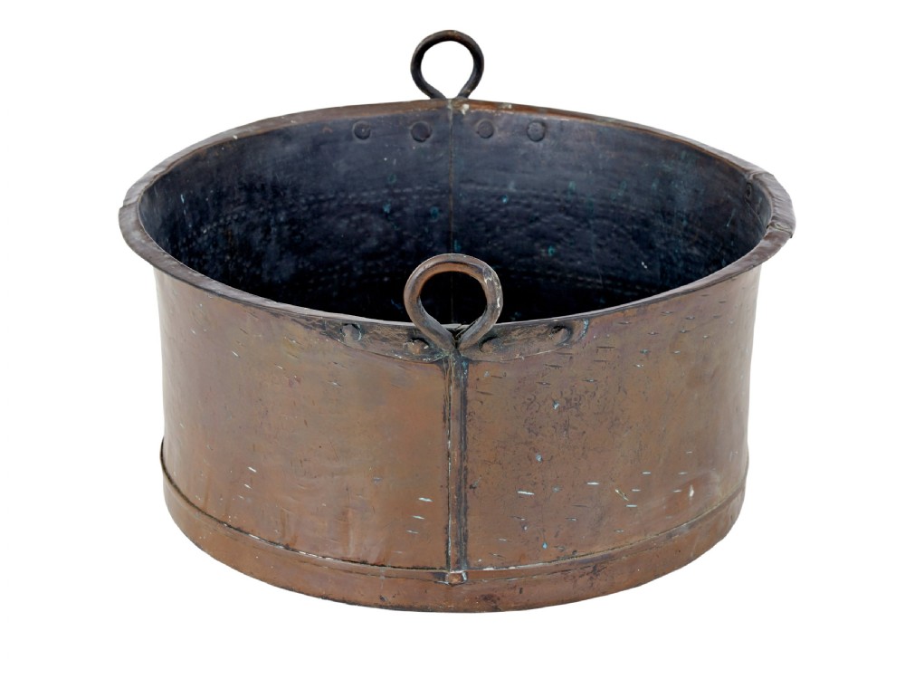 A large, circular nineteenth-century copper vessel with deep sides, hand-riveted seams, and two upright loop handles. View III