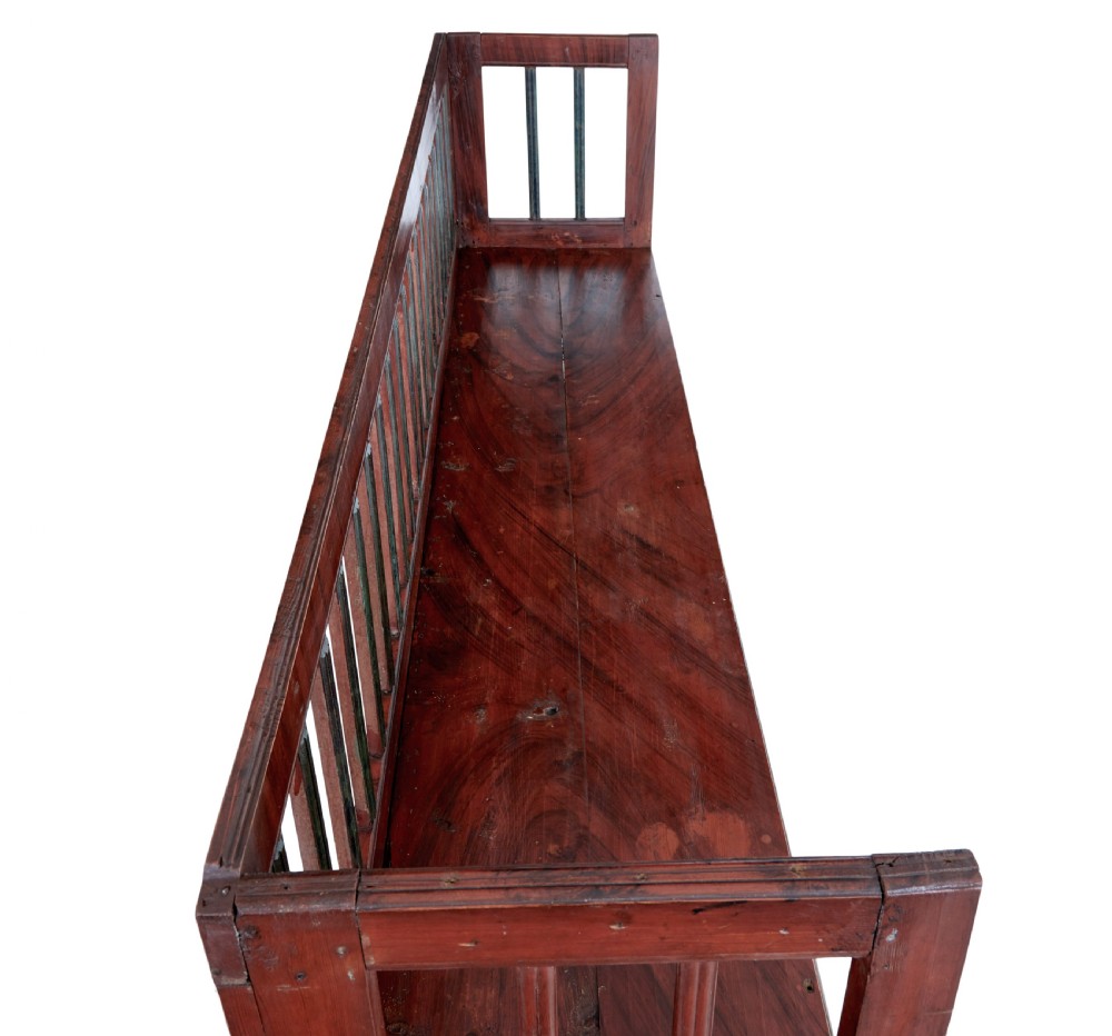 A mid 19th-century Swedish rustic pine bench featuring a dark red painted finish, a spindle backrest with contrasting dark green slats, and an enclosed box base. View II