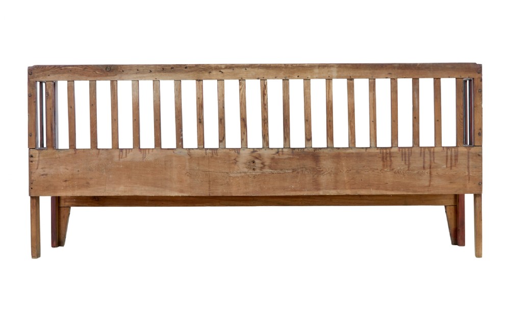 A mid 19th-century Swedish rustic pine bench featuring a dark red painted finish, a spindle backrest with contrasting dark green slats, and an enclosed box base. View VI