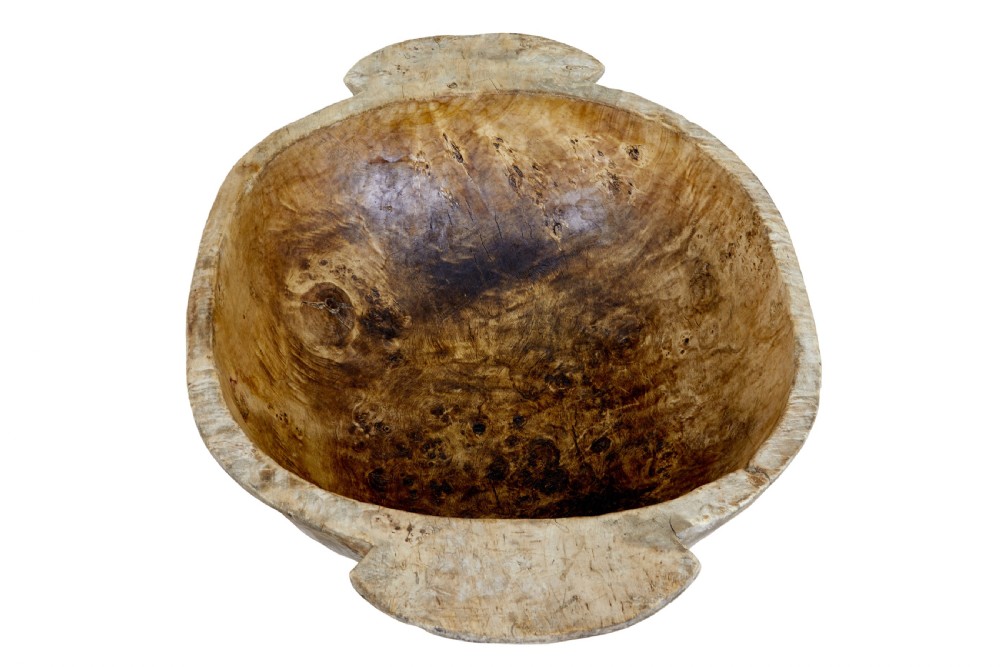 A large hand-carved rustic wooden bowl featuring side handles, hand-hewn tool marks, and natural timber grain. View V