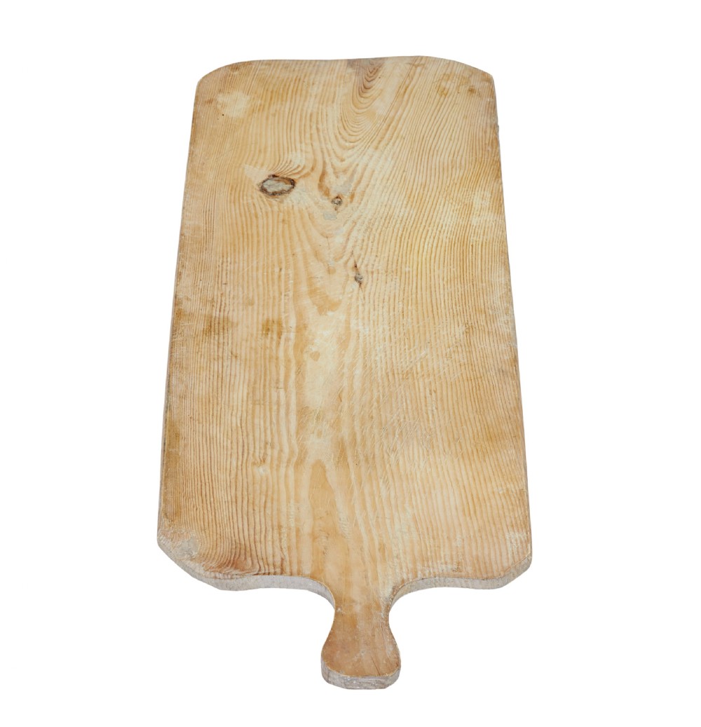 A long rectangular pale pine breadboard featuring a shaped handle at one end and natural timber grain with a knot. View II