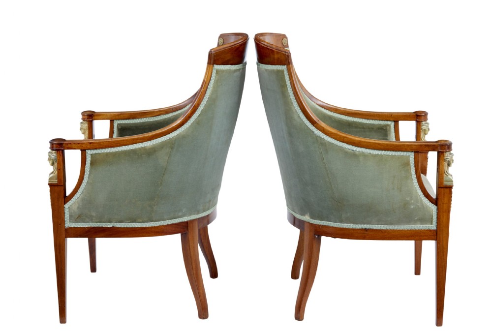 A three-piece Swedish Empire revival suite comprising two mahogany armchairs upholstered in green velvet with embroidered swag motifs and ormolu mounts alongside a matching round centre table with a triform base. View III
