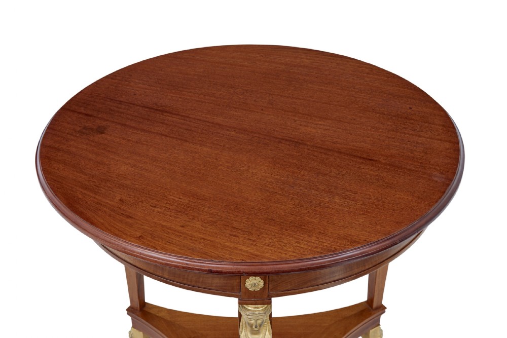 A three-piece Swedish Empire revival suite comprising two mahogany armchairs upholstered in green velvet with embroidered swag motifs and ormolu mounts alongside a matching round centre table with a triform base. View XI