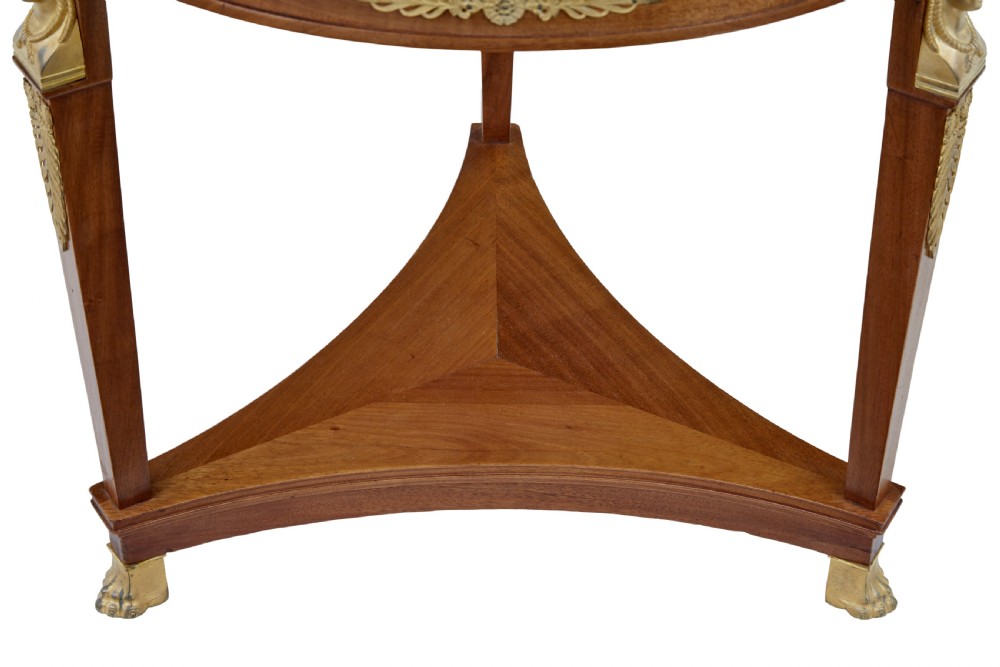 A three-piece Swedish Empire revival suite comprising two mahogany armchairs upholstered in green velvet with embroidered swag motifs and ormolu mounts alongside a matching round centre table with a triform base. View XII