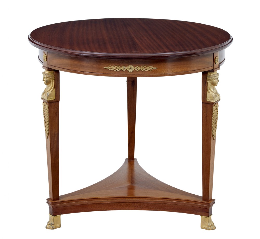A three-piece Swedish Empire revival suite comprising two mahogany armchairs upholstered in green velvet with embroidered swag motifs and ormolu mounts alongside a matching round centre table with a triform base. View XIII