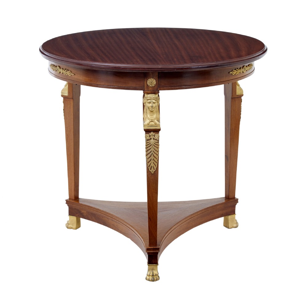 A three-piece Swedish Empire revival suite comprising two mahogany armchairs upholstered in green velvet with embroidered swag motifs and ormolu mounts alongside a matching round centre table with a triform base. View XIV
