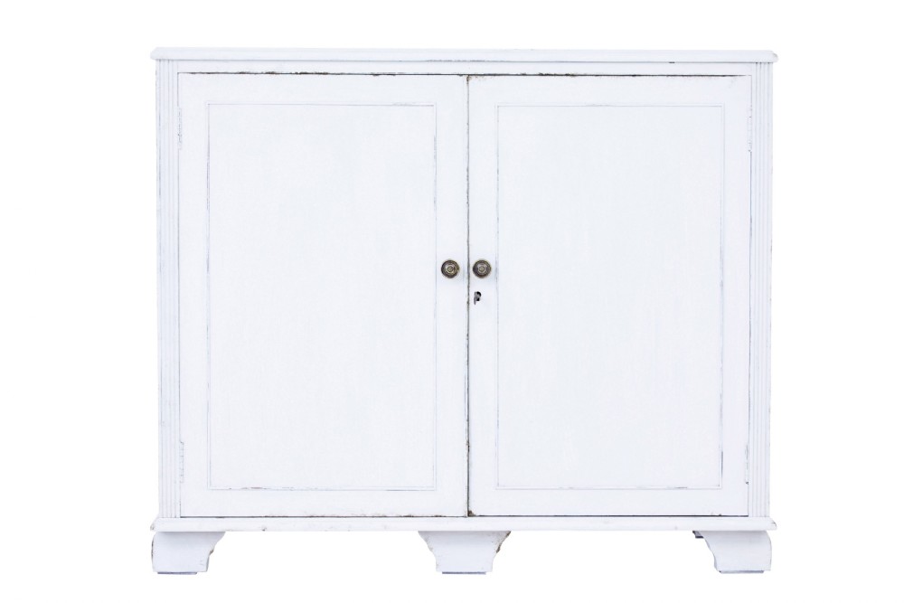 A 19th-century Swedish two-door cupboard painted in off-white, featuring simple panelled doors and small brass knobs.
