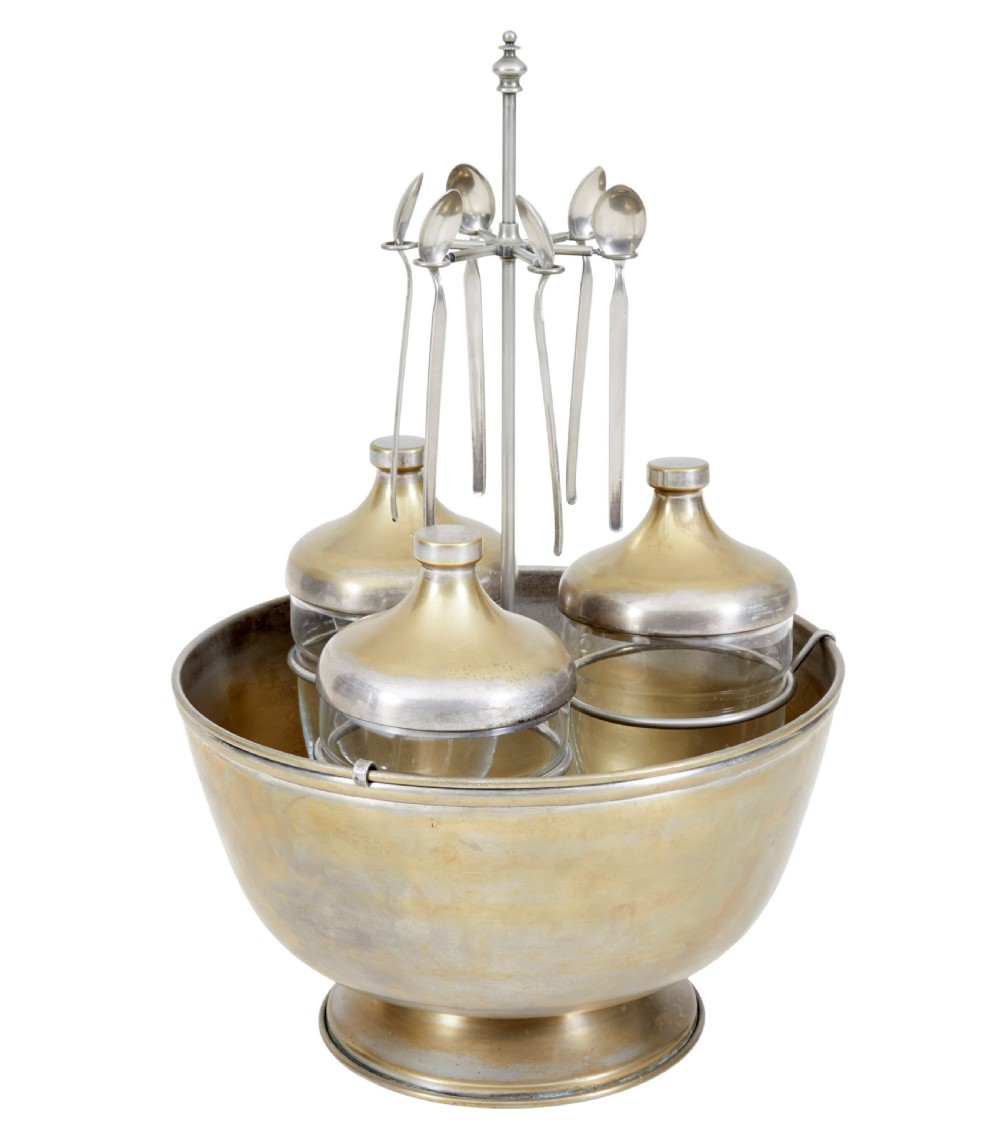 An early 20th-century Scandinavian metal and glass caviar ice server set featuring a central bowl, three lidded glass jars, and suspended spoons. View VI