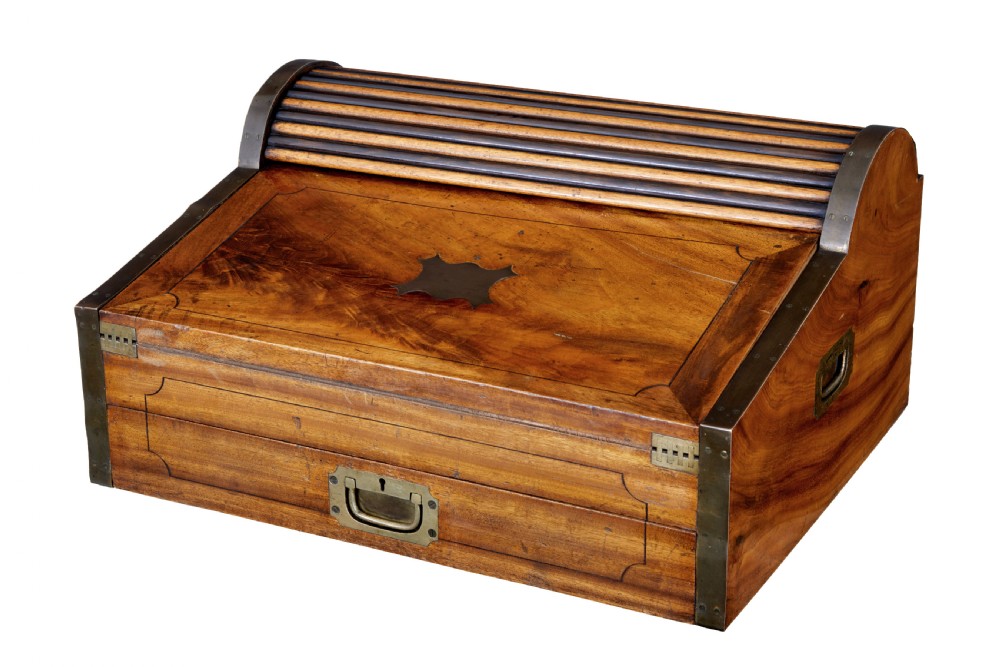 A mid-nineteenth century camphorwood campaign lap desk featuring a curved tambour roll top, sloped front, and recessed brass handles.