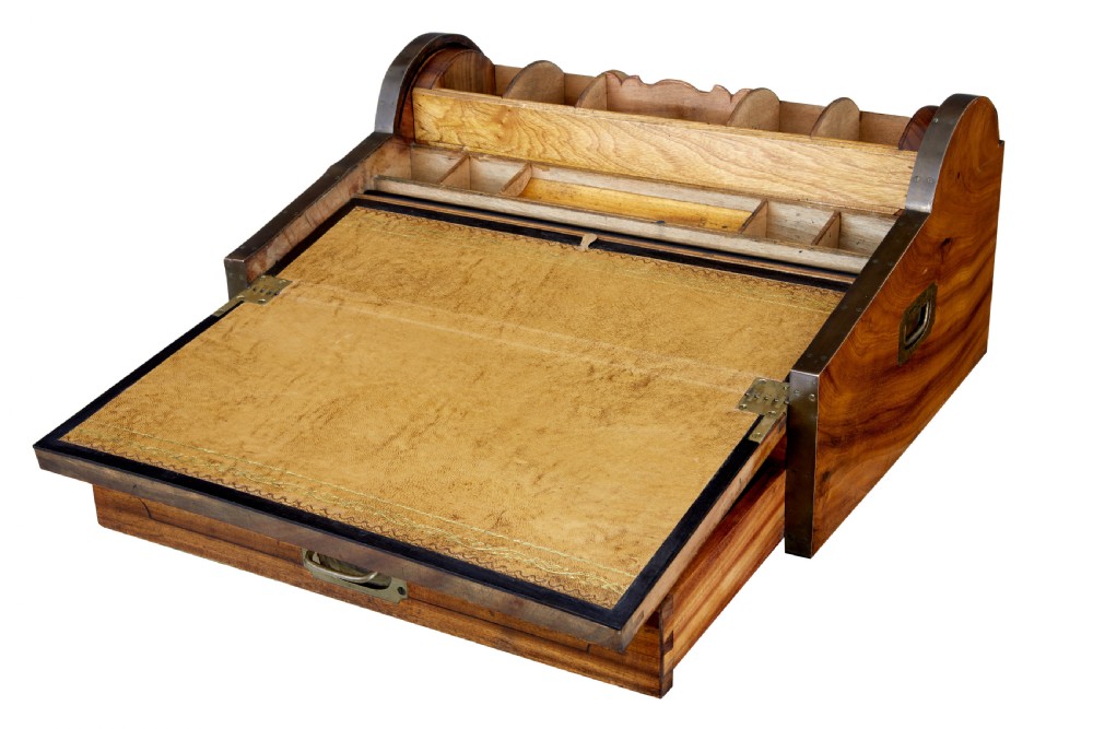 A mid-nineteenth century camphorwood campaign lap desk featuring a curved tambour roll top, sloped front, and recessed brass handles. View II