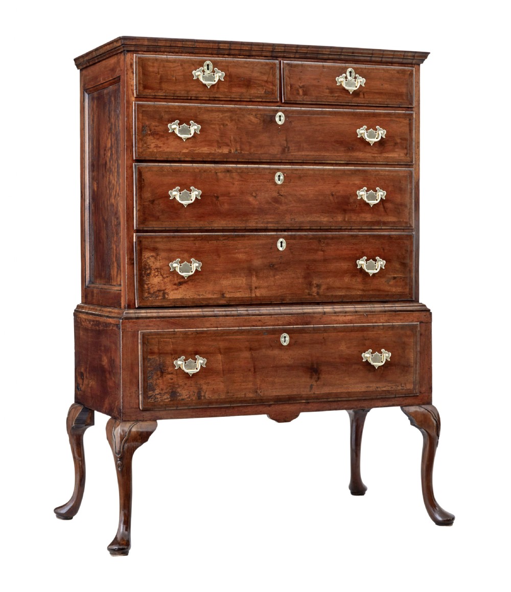 A late 17th-century William and Mary walnut chest on stand featuring five upper drawers, a single base drawer, decorative brass backplate handles, and cabriole legs.