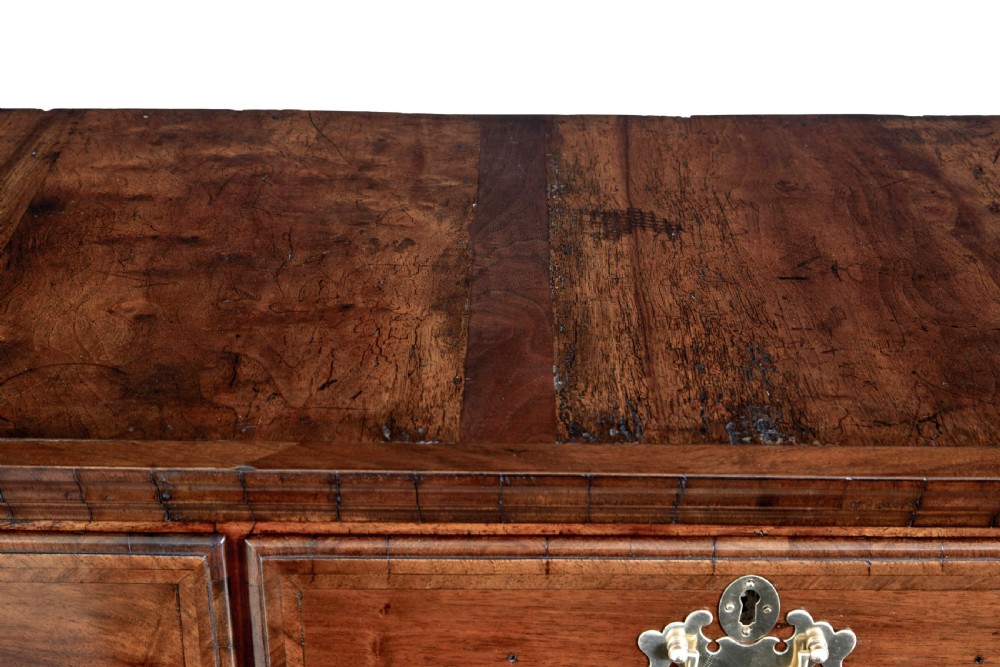 A late 17th-century William and Mary walnut chest on stand featuring five upper drawers, a single base drawer, decorative brass backplate handles, and cabriole legs. View X