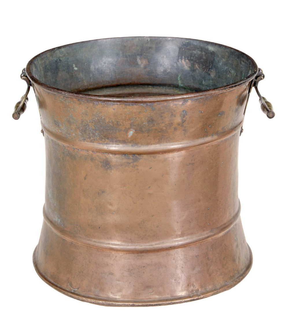 A cylindrical 19th-century copper vessel with horizontal ribbed banding and cast brass side handles. View VI