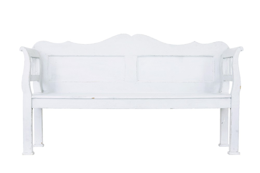 A white painted nineteenth-century Swedish Gustavian style wooden bench featuring a shaped crest rail, panelled back, and slatted side armrests. View II
