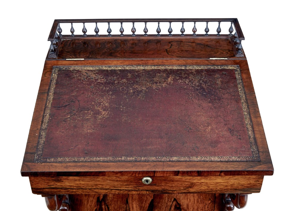 A 19th-century Regency palisander Davenport desk featuring a sloped leather writing top, carved scroll brackets, side drawers, and a brass spindle top gallery. View II