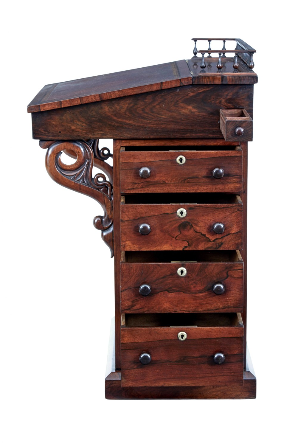 A 19th-century Regency palisander Davenport desk featuring a sloped leather writing top, carved scroll brackets, side drawers, and a brass spindle top gallery. View VII